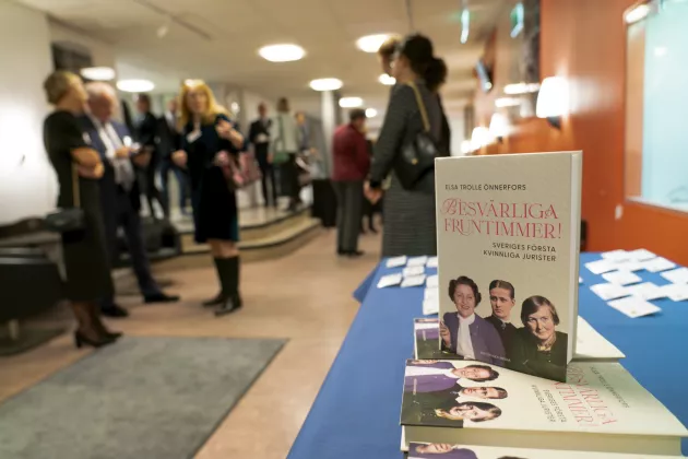 Boken Besvärliga fruntimmer på ett bord och några deltagare från seminariet i bakgrunden.