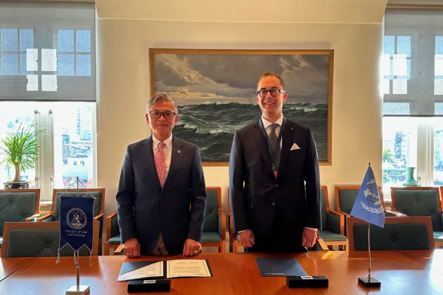 President, Professor Maximo Q. Mejia, Jr. och Professor Henrik Wenander framför skrivbord med signerad överenskommelse. Foto.